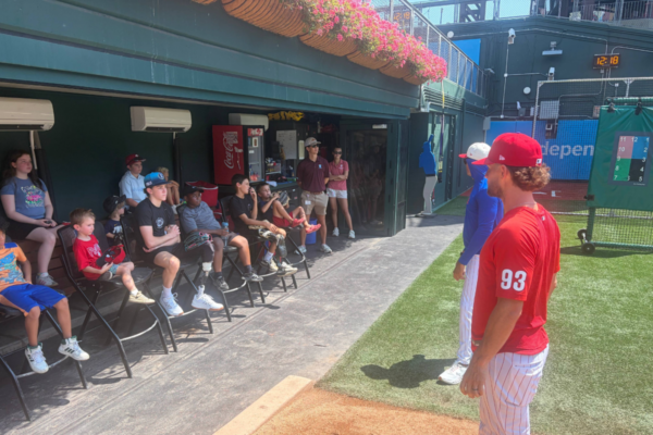 Youth participants sit along the dugout area at Citizens Bank Park while listening to instruction from Philadelphia Phillies coaches during the Toyota Phillies Coaches Clinic.