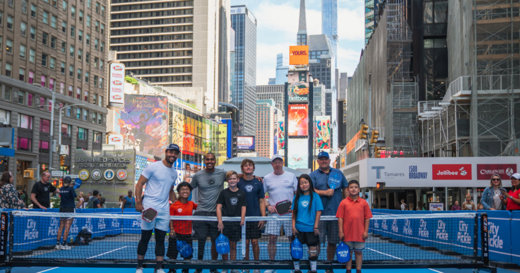 Participants and instructors gather on a CityPickle court in Times Square during a Challenged Athletes Foundation adaptive pickleball clinic in New York City.
