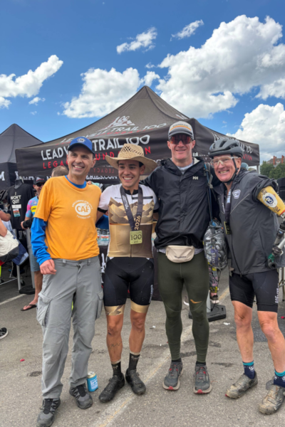 Leadville Trail 100 MTB finisher poses with supporters and fellow participants following the race in Leadville, Colorado.