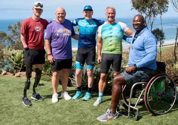 Challenged Athletes Foundation athletes, supporters, and cyclists gather overlooking the Pacific Ocean during a CAF community event celebrating adaptive sports and inclusion.
