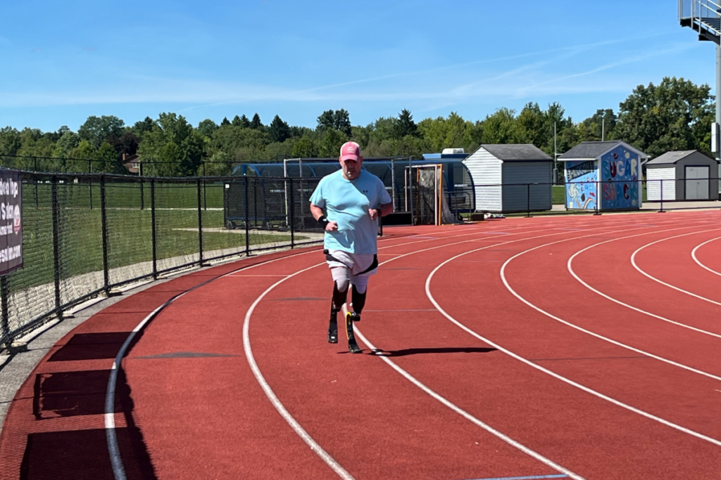 Jeff Belcher runs on an outdoor track using lower-limb prostheses.