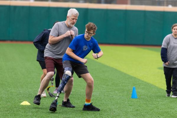 Community leaders and adaptive athletes gather on the field during a Challenged Athletes Foundation and Össur clinic event.