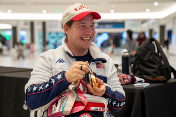 Andrew Kurka holds international competition medals, reflecting years of achievement in adaptive alpine skiing and Paralymic sport.