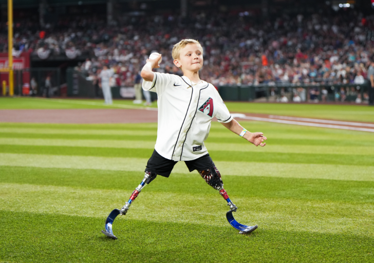 CAF athlete Beauden Baumkirchner prepares to throw a baseball on the field during a professional baseball game experience.