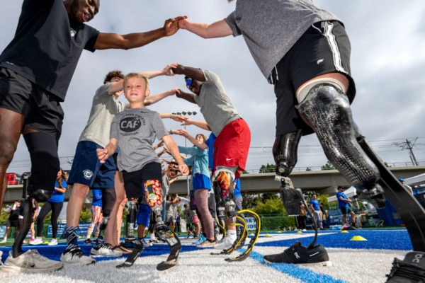 Beauden Baumkirchner runs through a tunnel of athletes and mentors during a Challenged Athletes Foundation adaptive sports camp.
