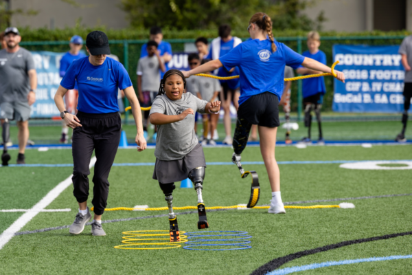 Young adaptive athlete completes a running drill with prosthetic blades during a CAF and Össur mobility and sports training event.