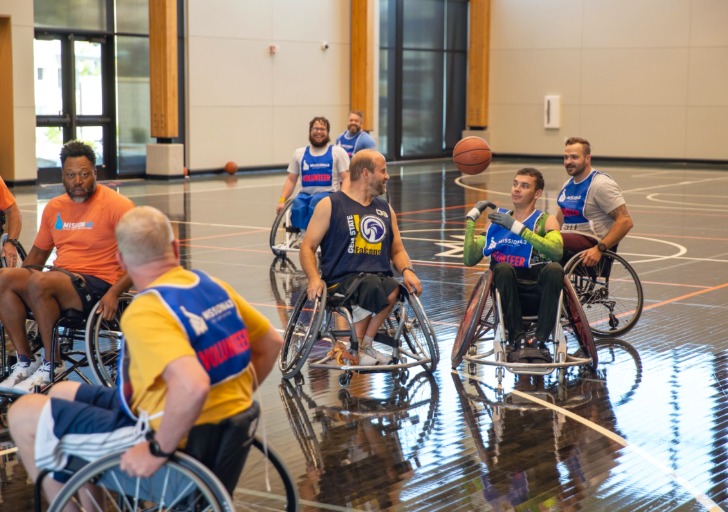 Eight people playing wheelchair basketball